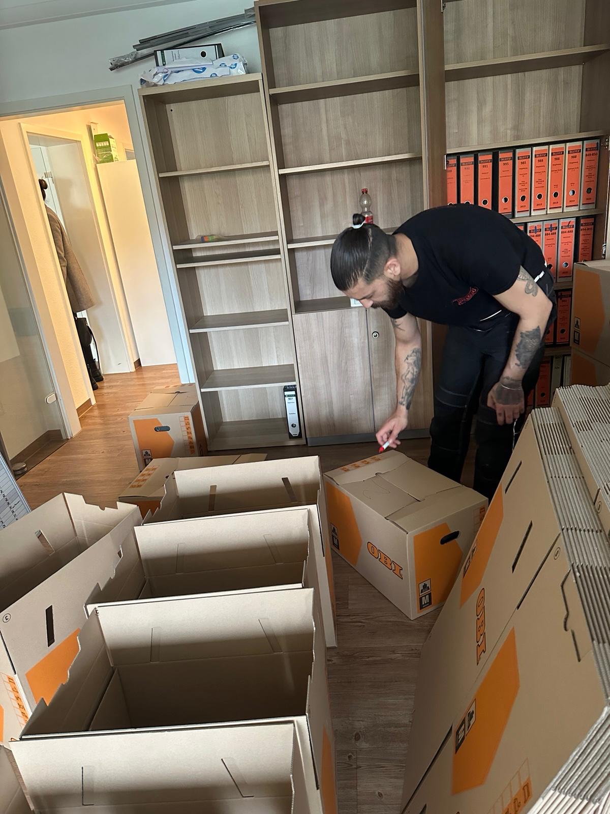 Profi-Umzugshelfer beim sorgfältigen Verpacken in Umzugskartons